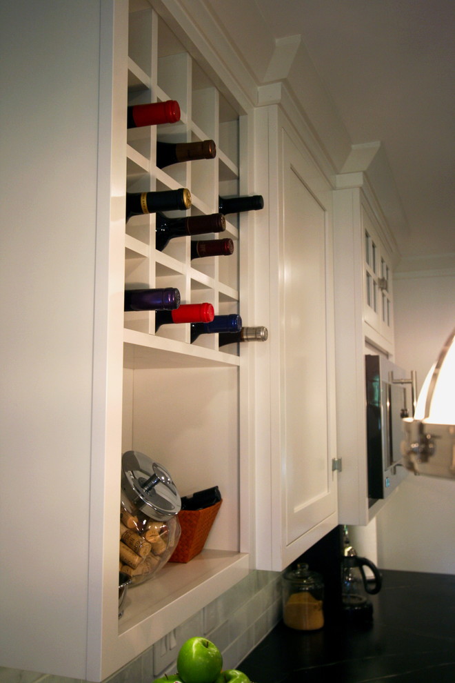 Example of a mid-sized l-shaped dark wood floor kitchen design in Cincinnati with a farmhouse sink, flat-panel cabinets, white cabinets, soapstone countertops, white backsplash, stone tile backsplash, stainless steel appliances and a peninsula
