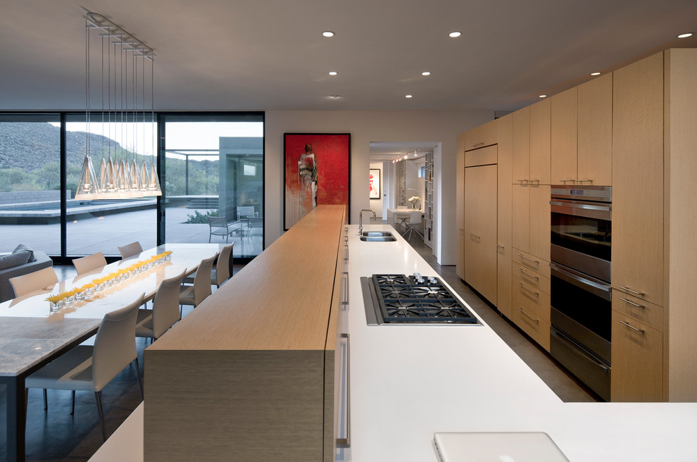 Modern galley eat-in kitchen in Phoenix with a double-bowl sink, flat-panel cabinets, light wood cabinets, panelled appliances and quartz benchtops.