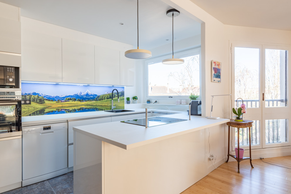 Idée de décoration pour cuisine ouverte in U With un évier posé, un placard à porte affleurante, des portes de placard blanches, un plan de travail en stratifié, une crédence multicolore, îlot, un sol gris and un plan de travail blanc.