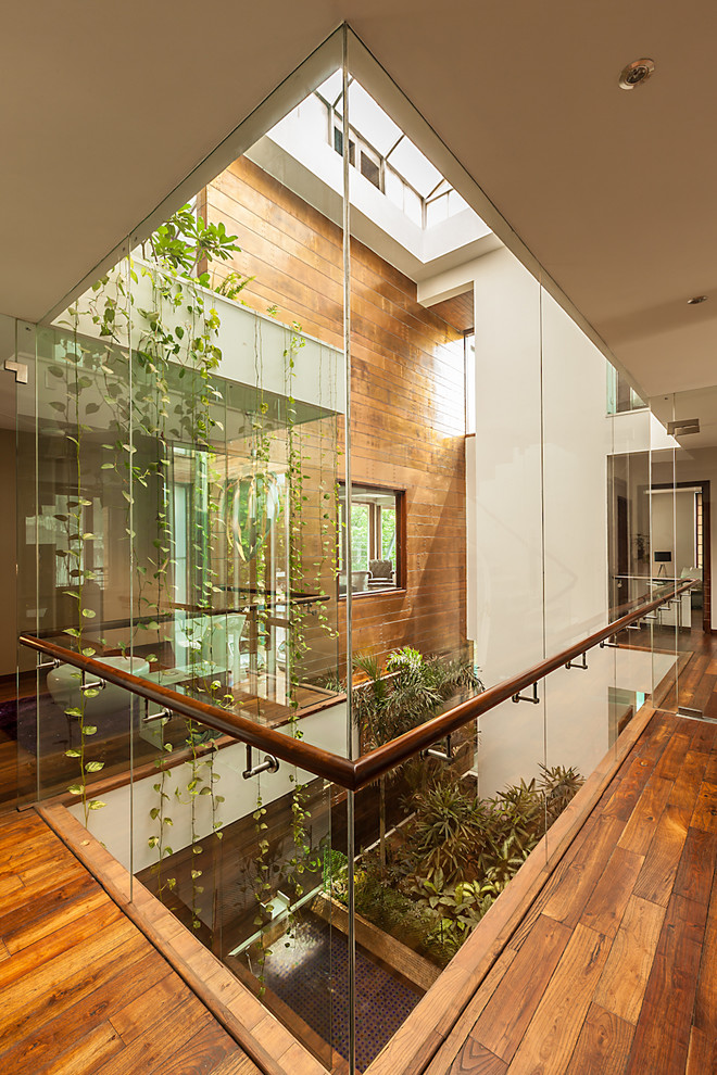 Inspiration for a contemporary corridor in Delhi With White Walls and Medium Hardwood Floors.