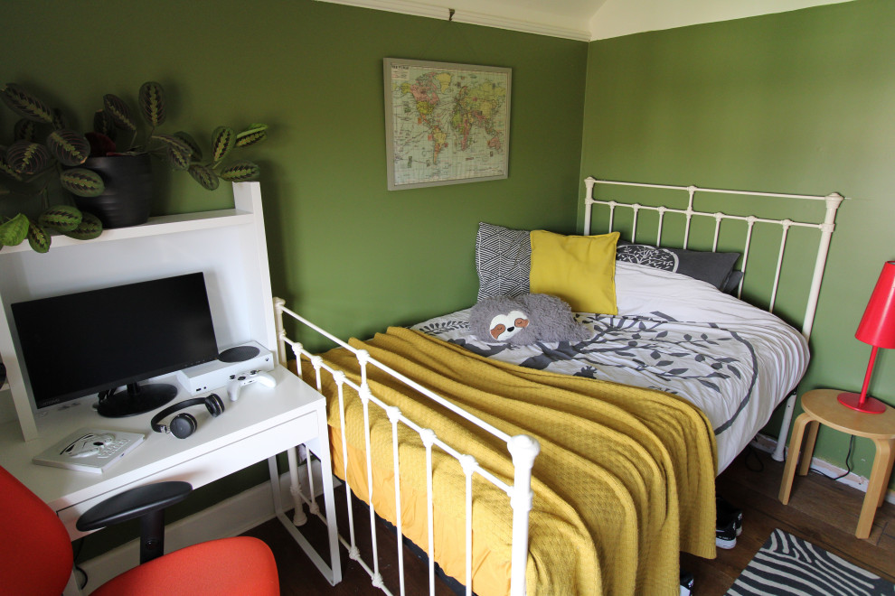 Medium sized eclectic bedroom with green walls, dark hardwood flooring and brown floors.