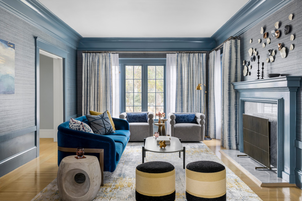 Réalisation d'un grand salon tradition ouvert avec un mur bleu, parquet clair, une cheminée standard, un manteau de cheminée en pierre, un sol beige et une bibliothèque ou un coin lecture.