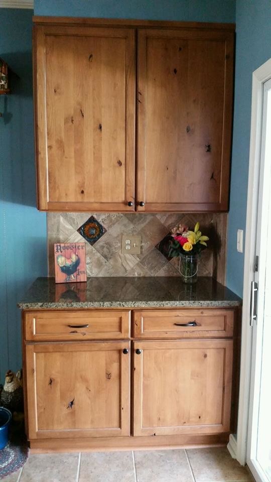 Mid-sized transitional l-shaped ceramic tile and brown floor eat-in kitchen photo in Baltimore with a farmhouse sink, flat-panel cabinets, medium tone wood cabinets, granite countertops, gray backsplash, ceramic backsplash, paneled appliances and an island