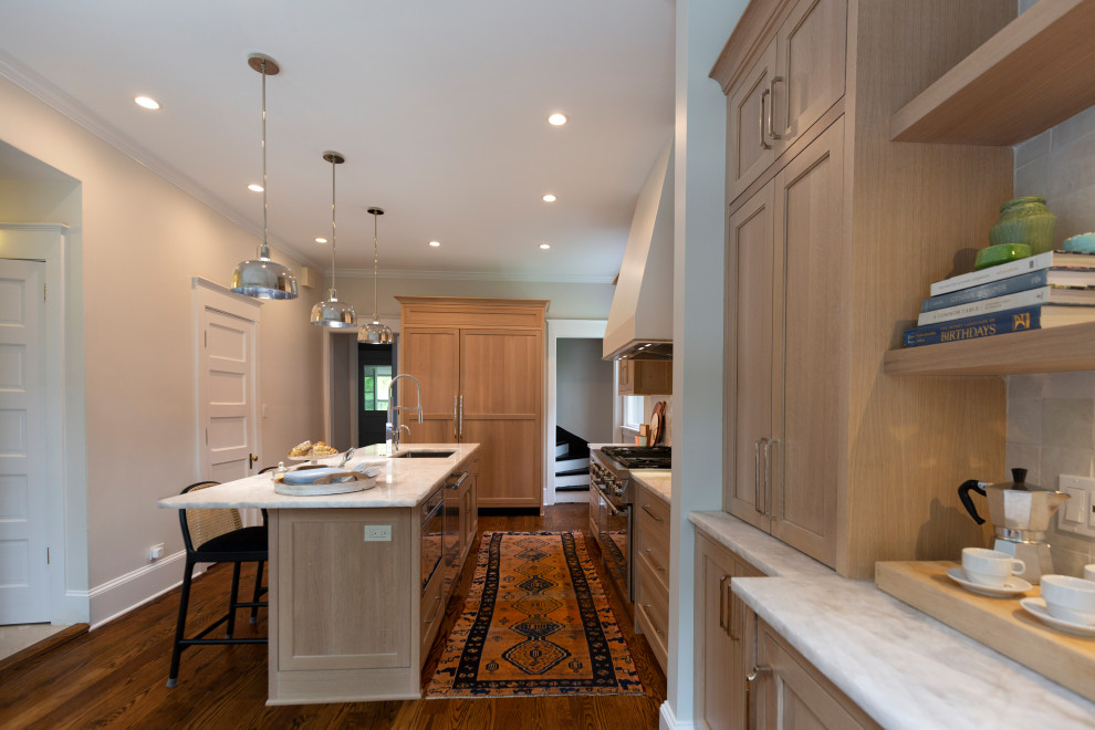 Photo of a large transitional l-shaped separate kitchen in Chicago with a single-bowl sink, recessed-panel cabinets, grey cabinets, quartzite benchtops, white splashback, ceramic splashback, panelled appliances, medium hardwood floors, with island, brown floor, beige benchtop and vaulted.