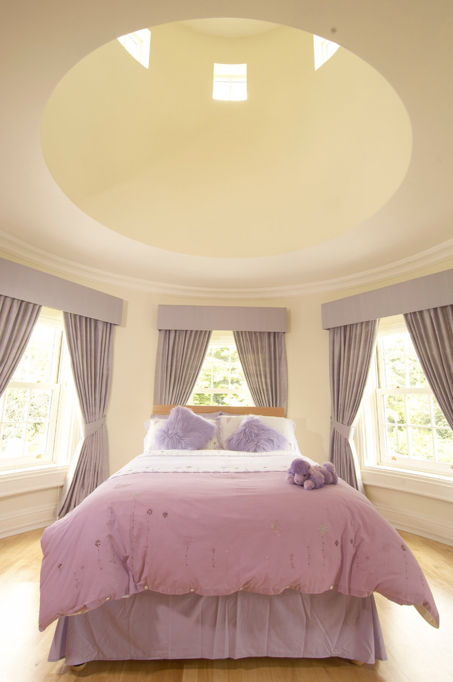 Design ideas for a traditional bedroom in London with beige walls and light hardwood floors.
