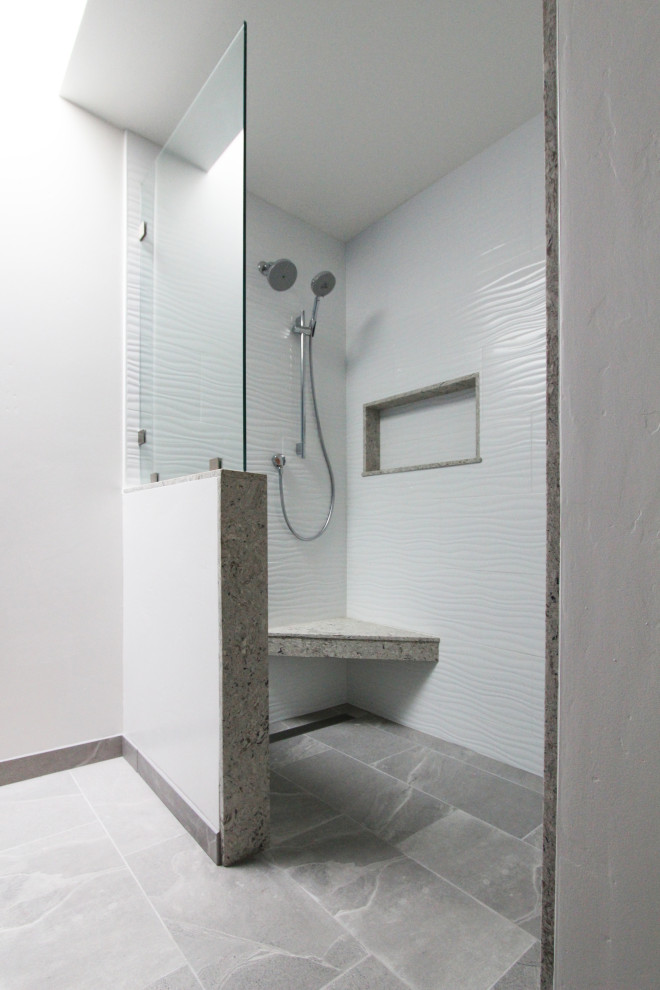 Example of a mid-sized transitional master white tile and porcelain tile porcelain tile, gray floor and double-sink walk-in shower design with shaker cabinets, gray cabinets, a two-piece toilet, blue walls, an undermount sink, quartz countertops, multicolored countertops, a niche and a built-in vanity