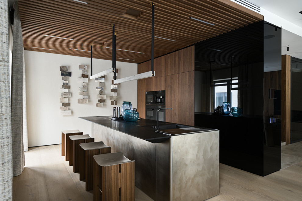 Foto de cocina lineal y blanca y madera actual grande abierta con puertas de armario de madera oscura, electrodomésticos con paneles y una isla