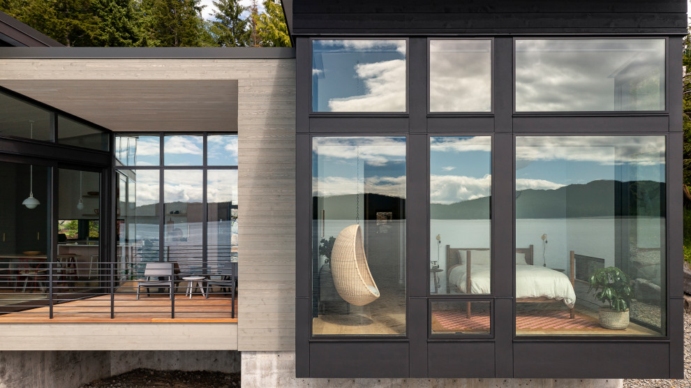 Cette image montre une terrasse minimaliste de taille moyenne avec une extension de toiture et un garde-corps en métal.