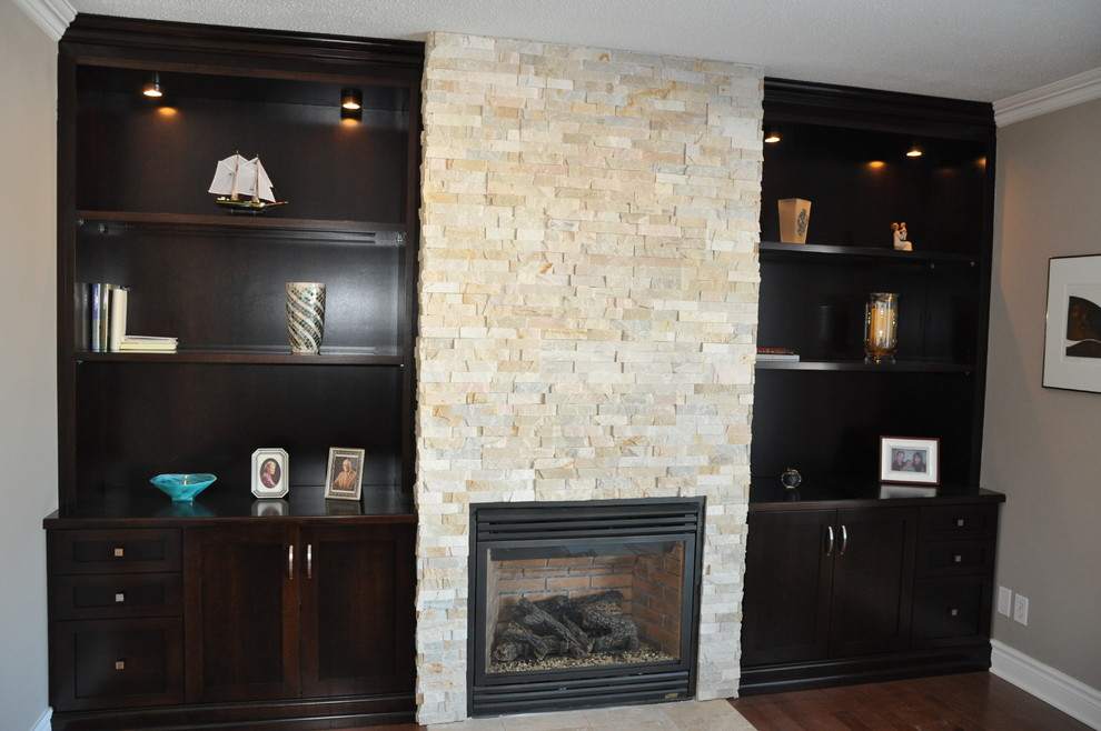 Design ideas for a mid-sized transitional open concept living room in Montreal with a library, grey walls, dark hardwood floors, a standard fireplace and a stone fireplace surround.