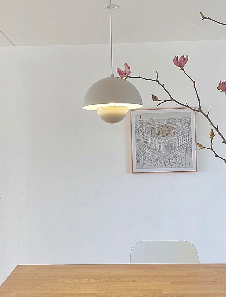 Idée de décoration pour une petite salle à manger ouverte sur la cuisine design avec un mur blanc, parquet clair et un sol jaune.
