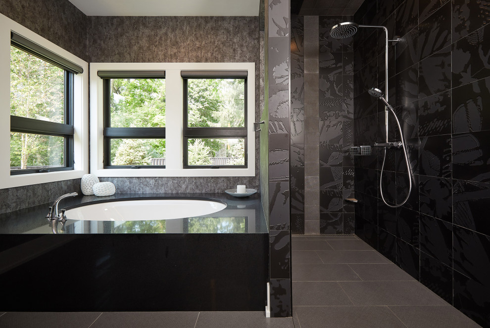 This is an example of a large contemporary ensuite bathroom in Grand Rapids with flat-panel cabinets, black cabinets, a corner bath, an alcove shower, black tiles, black walls, ceramic flooring, a submerged sink, engineered stone worktops, black floors, a hinged door, black worktops, double sinks, a floating vanity unit and wallpapered walls.