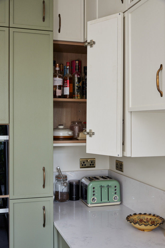 Modelo de cocinas en L clásica renovada pequeña cerrada con armarios con paneles empotrados, puertas de armario verdes, encimera de cuarcita, península y encimeras blancas