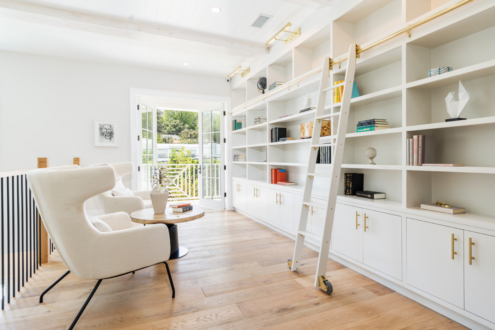 Transitional loft-style light wood floor family room library photo in Los Angeles with white walls