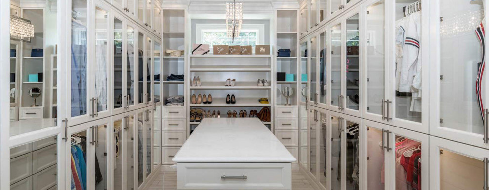 Idee per una cabina armadio chic con ante di vetro, ante bianche, pavimento in marmo e pavimento beige