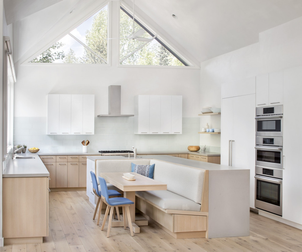 Inspiration for a medium sized scandi u-shaped kitchen in Denver with a submerged sink, white cabinets, engineered stone countertops, stainless steel appliances, medium hardwood flooring and an island.