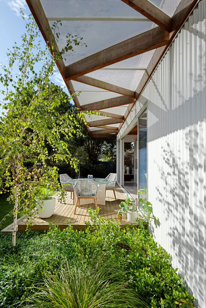Ejemplo de terraza planta baja vintage de tamaño medio en patio trasero y anexo de casas con barandilla de varios materiales