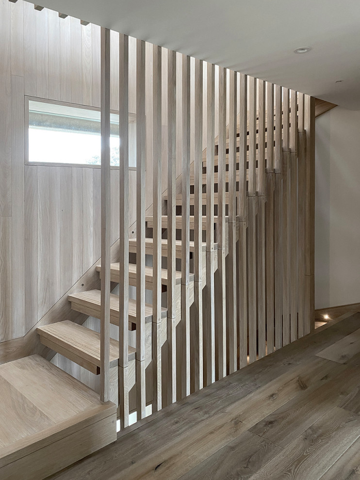 Modelo de escalera contemporánea de tamaño medio sin contrahuella con barandilla de madera, madera y escalones de madera