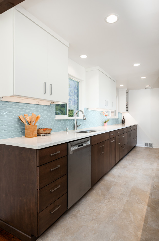 Inspiration for a mid-sized midcentury l-shaped open plan kitchen in Seattle with an undermount sink, flat-panel cabinets, dark wood cabinets, quartz benchtops, blue splashback, ceramic splashback, stainless steel appliances, vinyl floors, with island, beige floor and white benchtop.