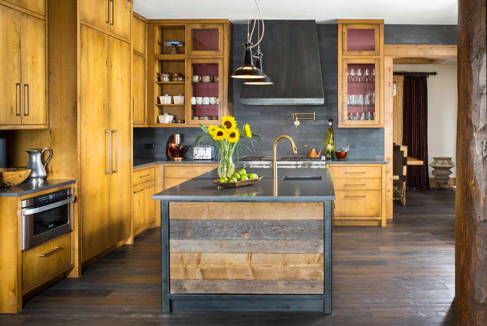 This is an example of a country l-shaped kitchen in Denver with a single-bowl sink, glass-front cabinets, medium wood cabinets, grey splashback, panelled appliances, dark hardwood floors and with island.