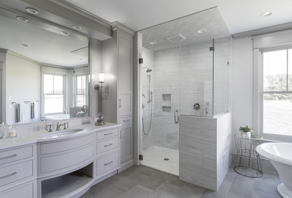 This is an example of a traditional ensuite bathroom in Grand Rapids with shaker cabinets, grey cabinets, a freestanding bath, an alcove shower, grey tiles, white tiles, white walls, a submerged sink, engineered stone worktops, a hinged door, white worktops, a single sink and a built in vanity unit.