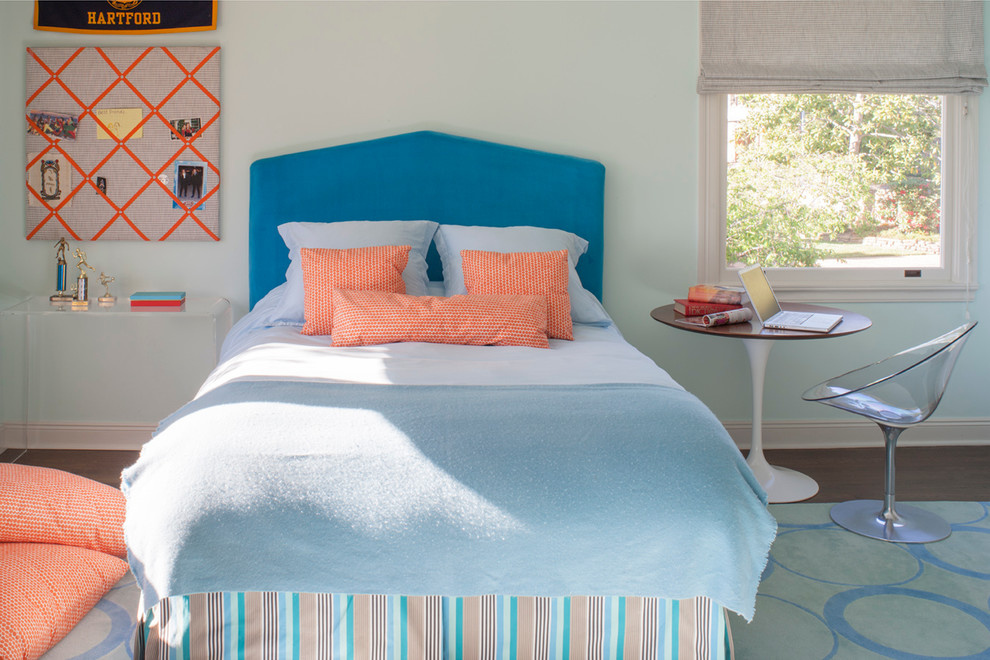 This is an example of a transitional kids' room for girls in San Francisco with blue walls and dark hardwood floors.