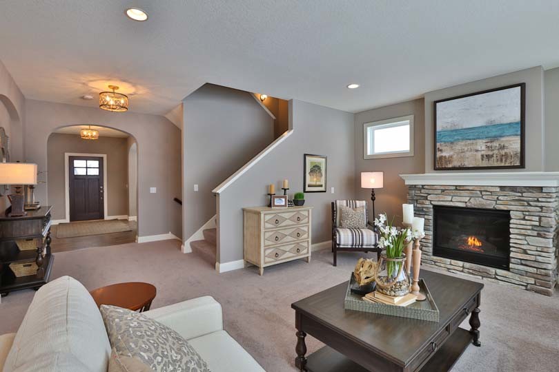 Photo of a mid-sized traditional open concept family room in Minneapolis with beige walls, carpet, a standard fireplace and a stone fireplace surround.