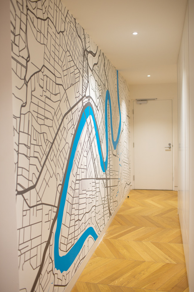 На фото: большой коридор в стиле модернизм с белыми стенами, паркетным полом среднего тона и обоями на стенах