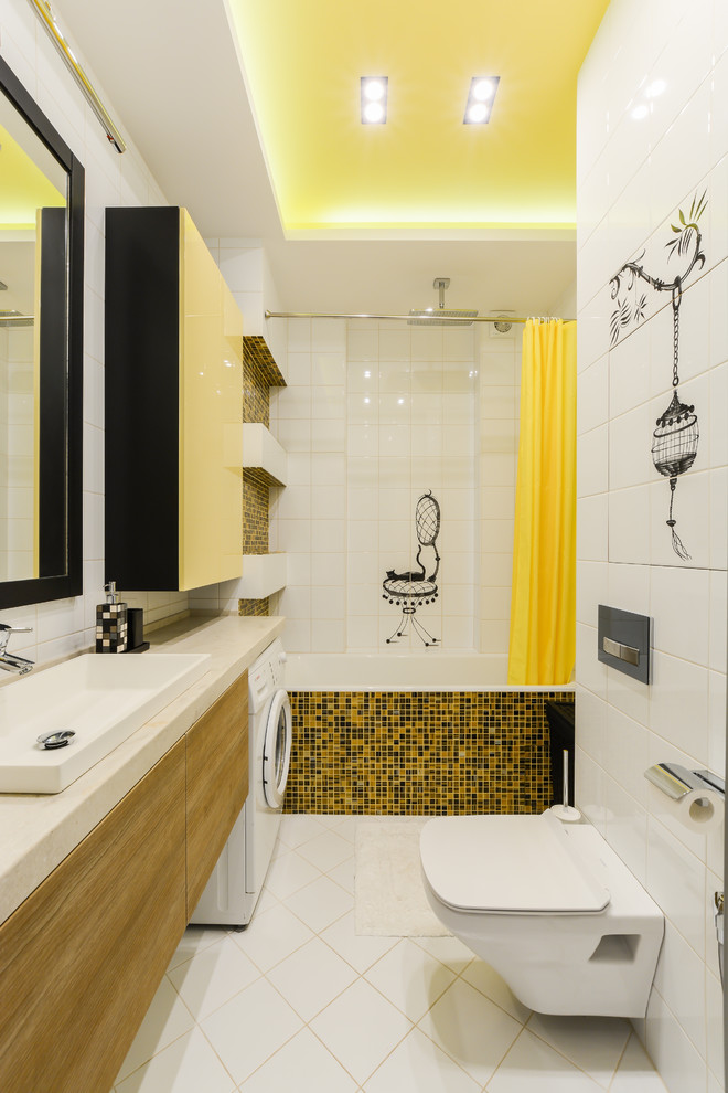 This is an example of a mid-sized contemporary master bathroom in Other with flat-panel cabinets, medium wood cabinets, an alcove tub, a shower/bathtub combo, a wall-mount toilet, white tile, yellow tile, black tile, white walls, mosaic tile, a vessel sink and a shower curtain.