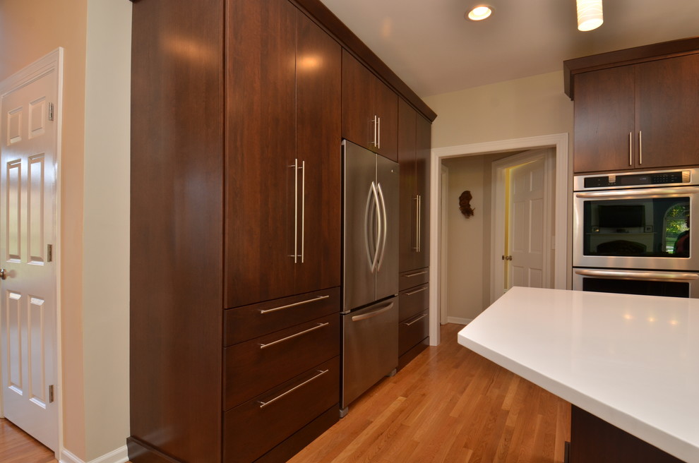 Inspiration for a mid-sized transitional l-shaped light wood floor eat-in kitchen remodel in Chicago with an undermount sink, flat-panel cabinets, dark wood cabinets, quartzite countertops, multicolored backsplash, matchstick tile backsplash, stainless steel appliances and an island