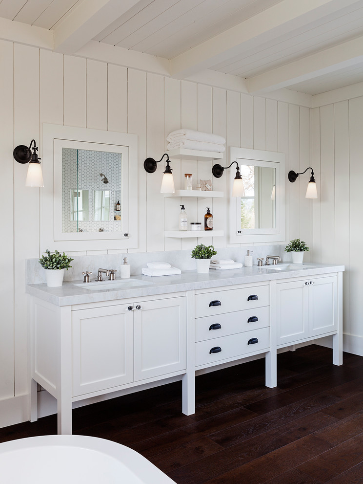 Photo of a mid-sized country master bathroom in San Francisco with raised-panel cabinets, white cabinets, a freestanding tub, an open shower, a one-piece toilet, white tile, mosaic tile, white walls, dark hardwood floors, a drop-in sink, granite benchtops and an open shower.