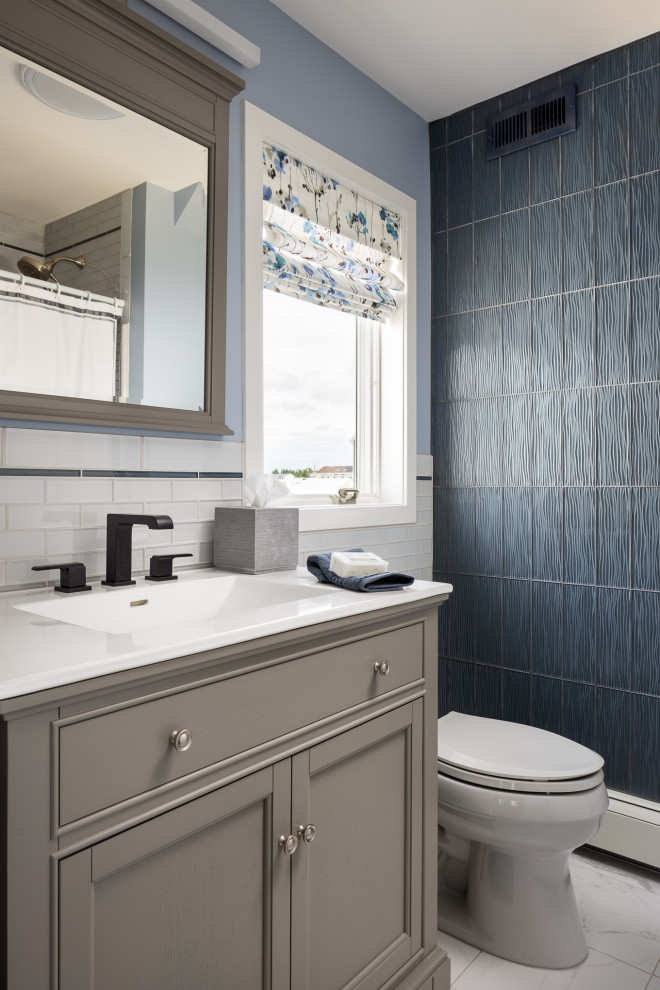 This is an example of a small beach style 3/4 bathroom in New York with recessed-panel cabinets, grey cabinets, blue tile, glass tile, purple walls, ceramic floors, an integrated sink, engineered quartz benchtops, multi-coloured floor, white benchtops, a single vanity and a freestanding vanity.