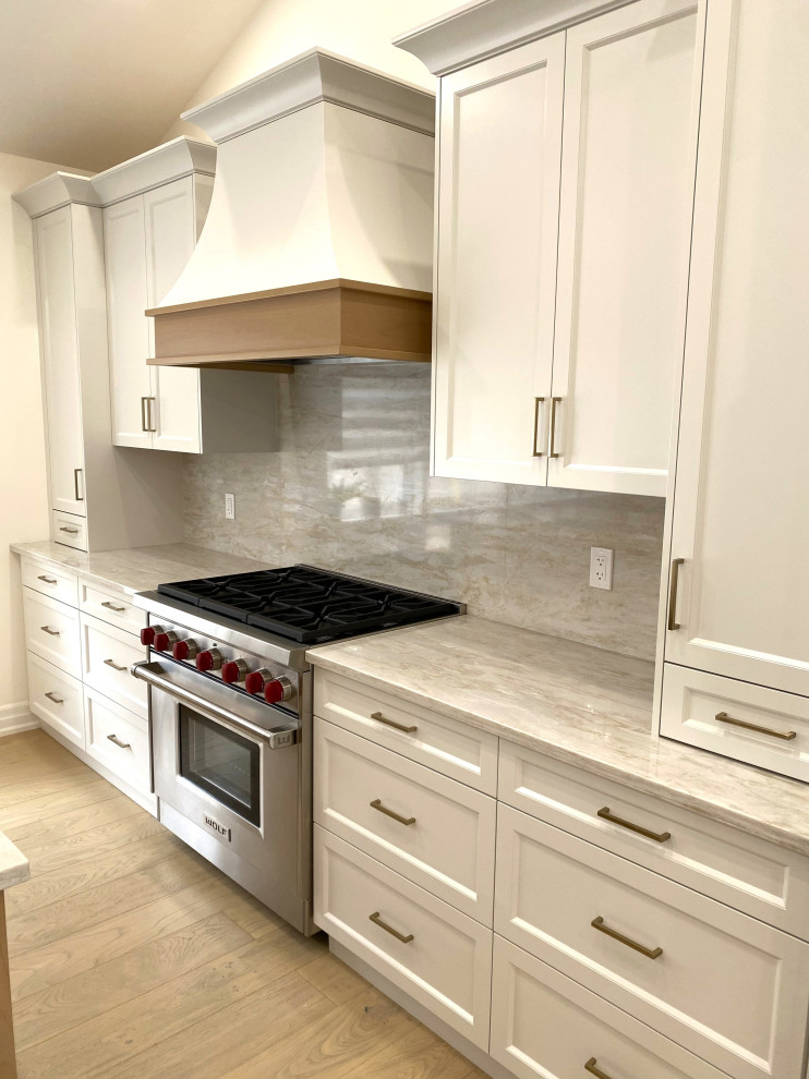 Inspiration for a small transitional galley light wood floor and vaulted ceiling open concept kitchen remodel in Toronto with an undermount sink, recessed-panel cabinets, white cabinets, quartz countertops, quartz backsplash and stainless steel appliances