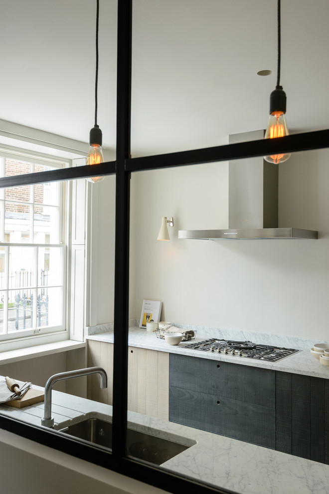 Design ideas for a small contemporary galley eat-in kitchen in London with an integrated sink, flat-panel cabinets, granite benchtops, panelled appliances, light hardwood floors and no island.