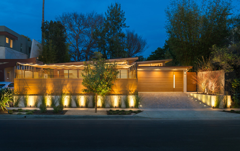 This is an example of a mid-sized contemporary one-storey brown exterior in Los Angeles with wood siding and a shed roof.