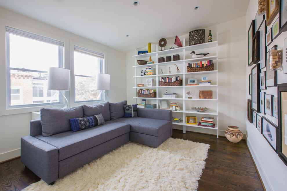 This is an example of a small contemporary enclosed family room in DC Metro with white walls and medium hardwood floors.