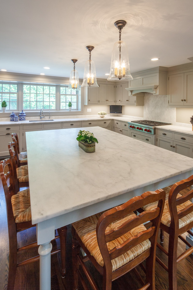 Inspiration for a large transitional l-shaped dark wood floor kitchen remodel in Boston with a single-bowl sink, beaded inset cabinets, gray cabinets, marble countertops, gray backsplash, stone slab backsplash, paneled appliances and an island
