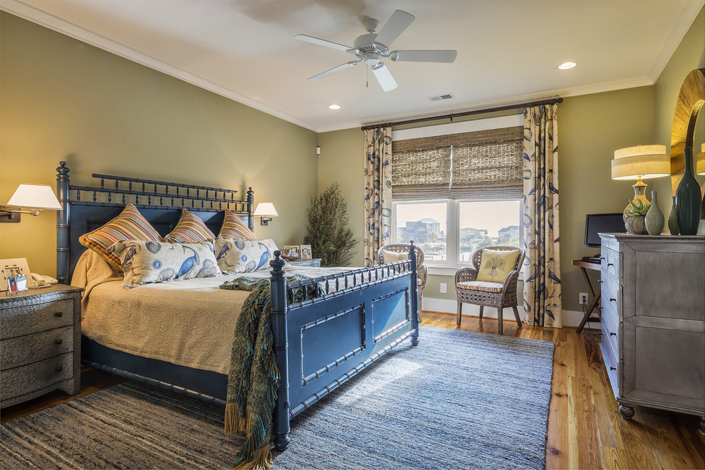Design ideas for a beach style bedroom in Charlotte with green walls and medium hardwood floors.