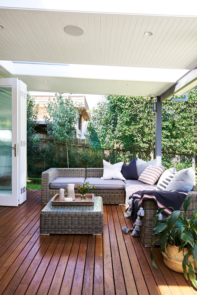 Photo of a large transitional backyard deck in Sydney with a roof extension.