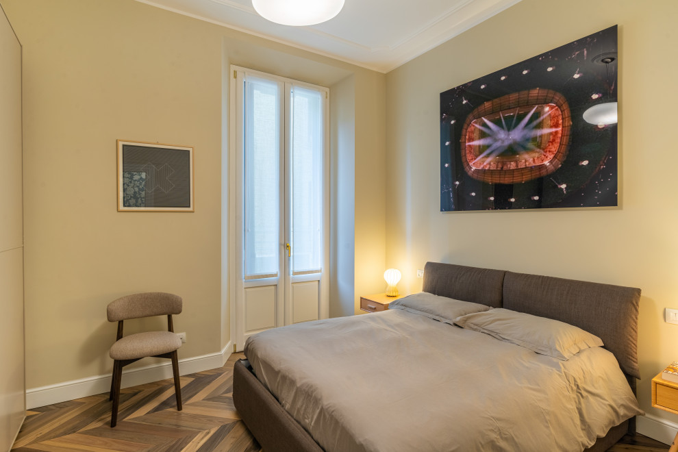 Immagine di una camera da letto contemporanea con parquet chiaro e pareti beige