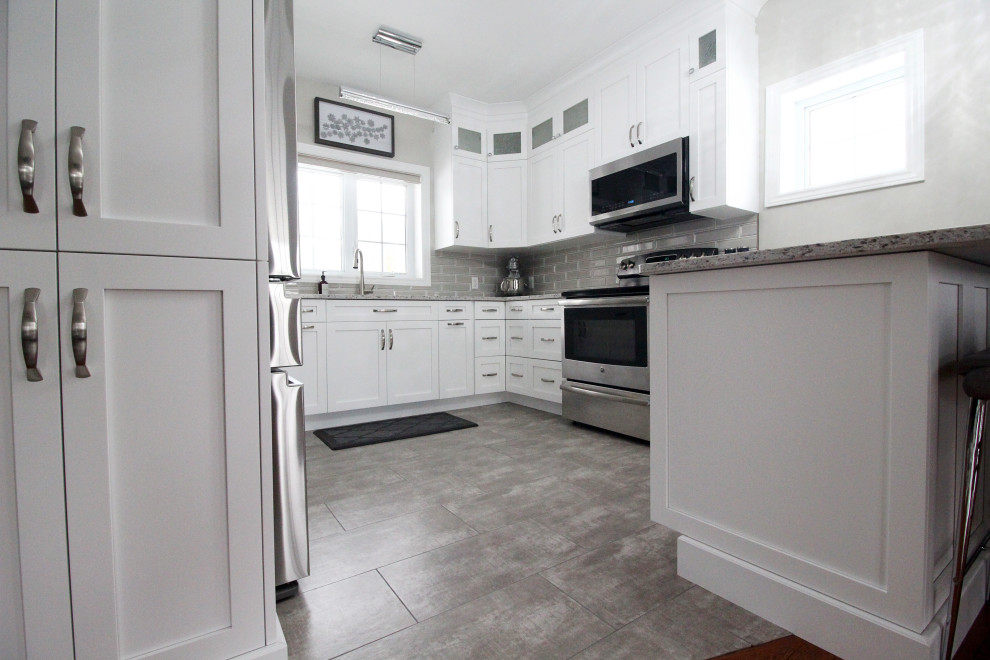 Kitchen - u-shaped kitchen idea with shaker cabinets, white cabinets, quartzite countertops, gray backsplash, subway tile backsplash, a peninsula and gray countertops