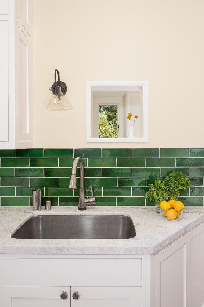 Photo of a mid-sized transitional u-shaped kitchen in San Francisco with an undermount sink, shaker cabinets, white cabinets, marble benchtops, green splashback, subway tile splashback, stainless steel appliances, medium hardwood floors and with island.