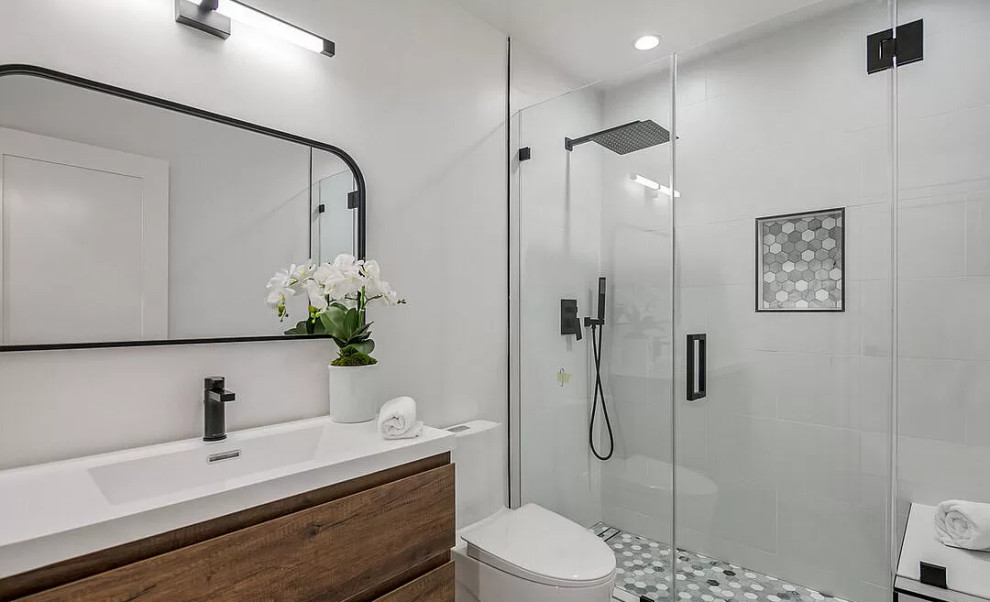 На фото: ванная комната среднего размера в современном стиле с белыми фасадами, ванной в нише, душем в нише, унитазом-моноблоком, белой плиткой, цементной плиткой, белыми стенами, светлым паркетным полом, душевой кабиной, накладной раковиной, столешницей из искусственного кварца, коричневым полом, душем с распашными дверями, белой столешницей, нишей, тумбой под одну раковину и встроенной тумбой