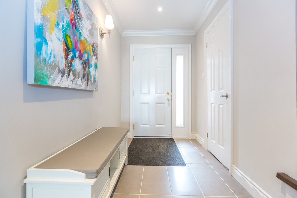 Small transitional foyer in Toronto with ceramic floors.