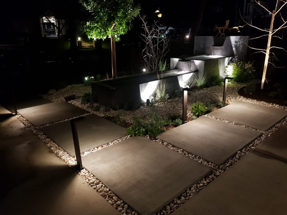 Diseño de patio minimalista en patio delantero con fuente y adoquines de ladrillo