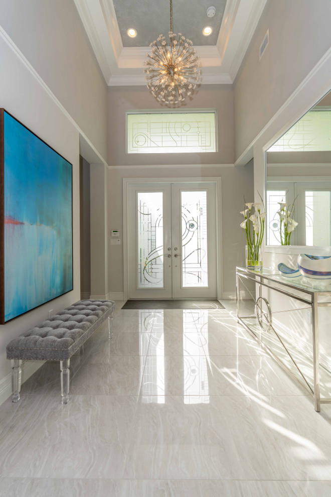 Example of a mid-sized transitional marble floor, beige floor and coffered ceiling entryway design in Miami with beige walls and a glass front door