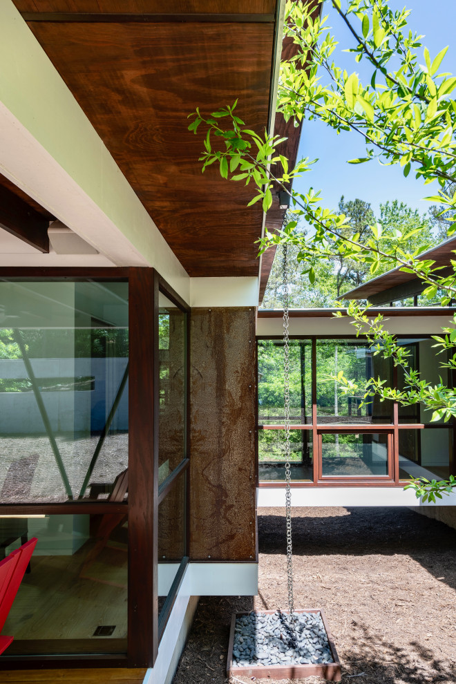 Imagen de fachada de casa blanca minimalista de tamaño medio de una planta con revestimiento de metal y techo de mariposa
