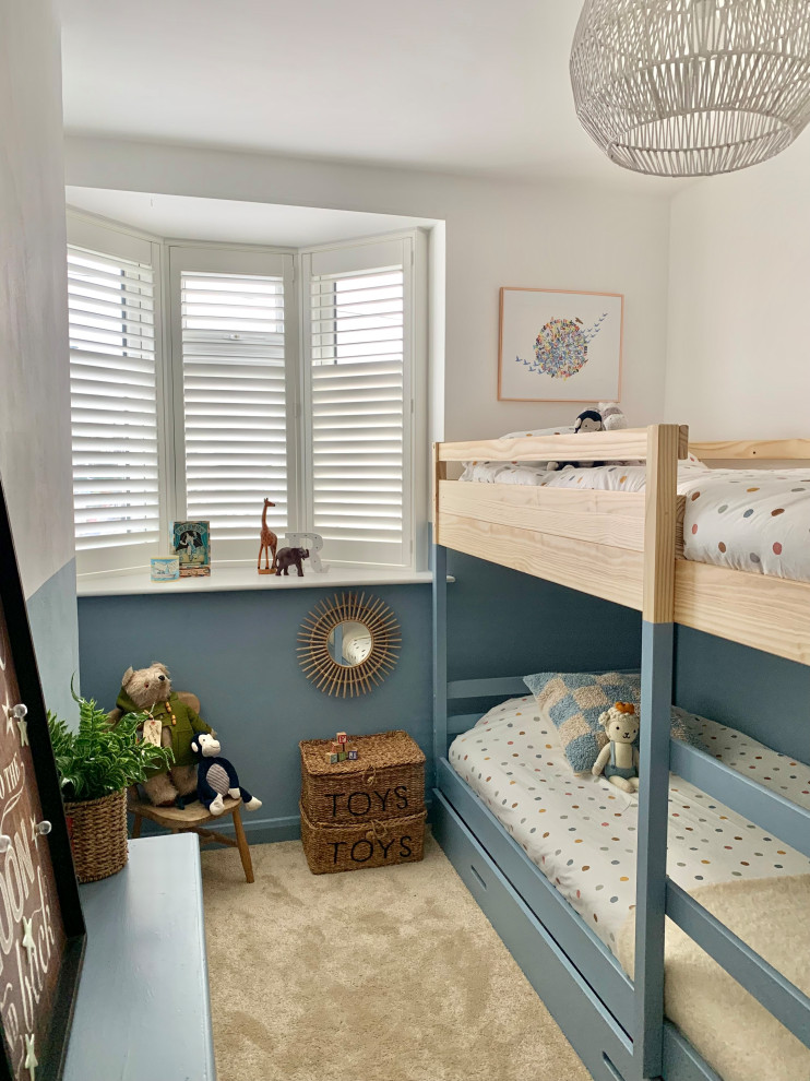 Ispirazione per una piccola cameretta per bambini da 4 a 10 anni design con pareti blu, moquette e pavimento beige