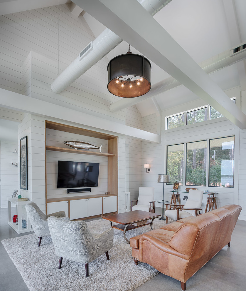 Photo of a country open concept family room in Other with white walls, a wall-mounted tv and grey floor.