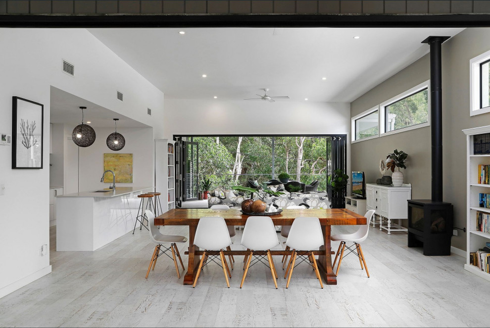 This is an example of a large contemporary open plan dining in Central Coast with laminate floors, a standard fireplace, grey walls and grey floor.