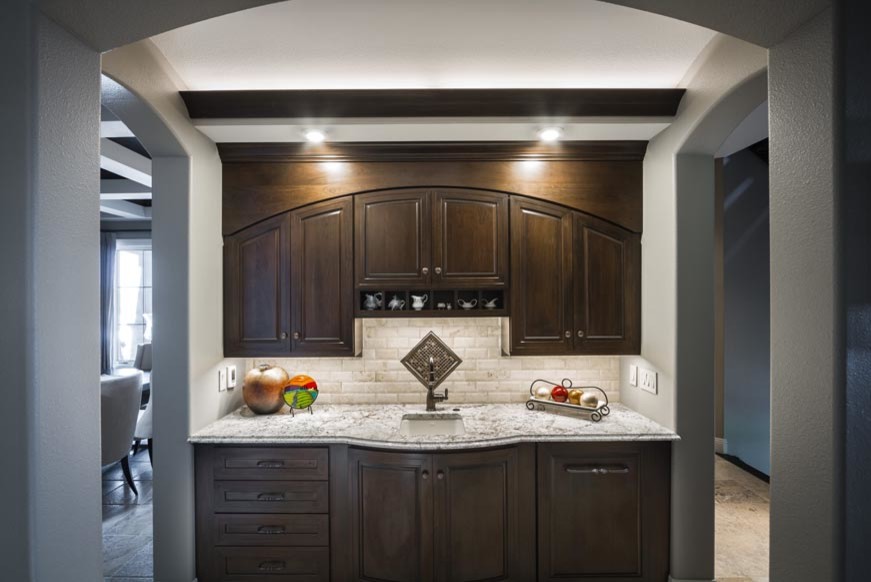 Inspiration for a transitional eat-in kitchen remodel with an undermount sink, raised-panel cabinets, dark wood cabinets, stainless steel appliances and an island